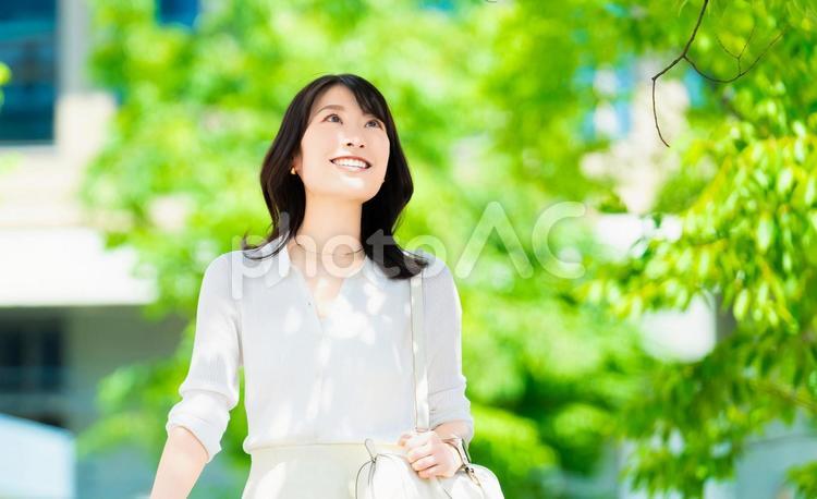 屋外を歩く笑顔の女性・ビジネスウーマン 女性,歩く,夏の写真素材