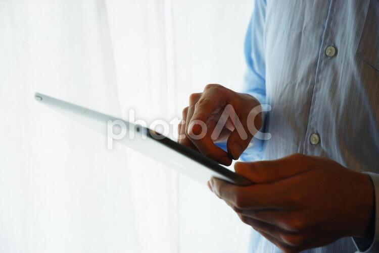 タブレットを操作する男性１ タブレット,男性,デバイスの写真素材