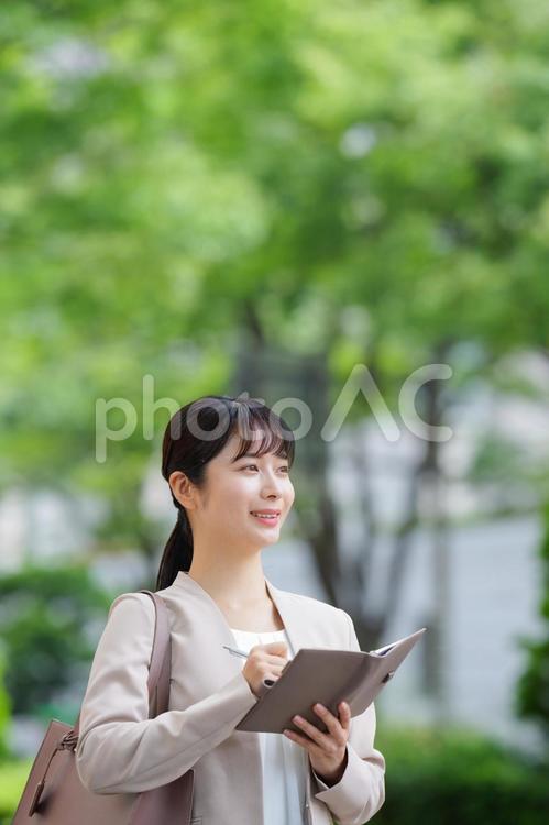 手帳を持ってメモする女性 女性,人物,大学生の写真素材