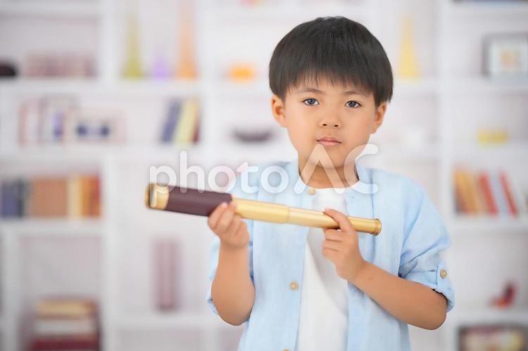 本棚背景で望遠鏡を持っている男の子 男の子,日本人,ポートレートの写真素材