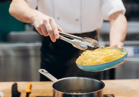 鍋にトングで麺を入れるシェフ 鍋にトングで麺を入れるシェフ キュイジーヌ,キッチン,厨房の写真素材