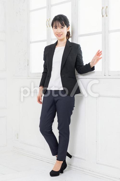 白い部屋に立ってポーズをとる、ジャケットを着た若い女性 女性,立つ,ジャケットの写真素材