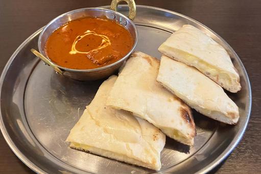 チーズナンとバターチキンカレーの写真
