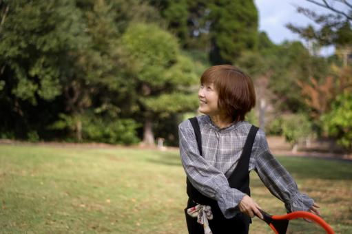 <人物>公園でラケットで元気に遊ぶ女性 <人物>公園でラケットで元気に遊ぶ女性 女性,笑顔,テニスの写真素材