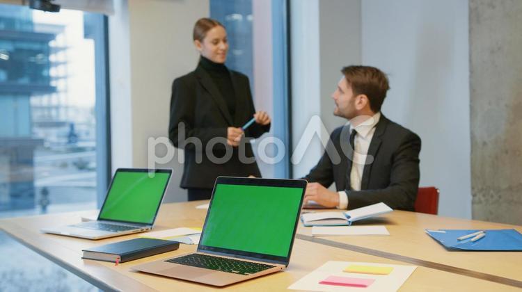 ペンを持ち座っている男性と話している女性 男女,ビジネス,笑顔の写真素材