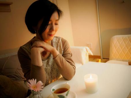 36:キャンドルを眺めてお茶を楽しむ女性 36:キャンドルを眺めてお茶を楽しむ女性 キャンドル,お茶,リラックスの写真素材