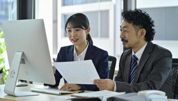 上司にデータを説明する女性社員 上司にデータを説明する女性社員の写真