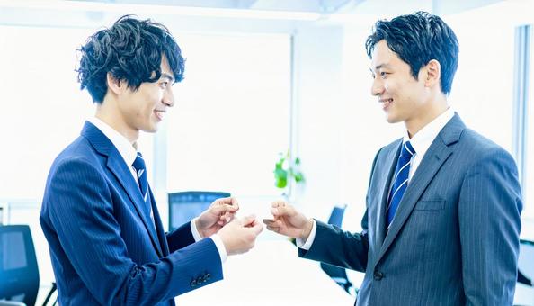 丁寧な名刺交換をする男性ビジネスパーソン 丁寧な名刺交換をする男性ビジネスパーソンの写真