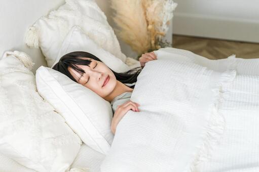 ベッドで眠る若いアジア人女性（睡眠） 睡眠,安眠,ベッドの写真素材