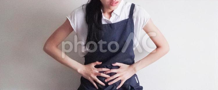 腹痛に苦しむ女性(横長) 女性,腹痛,お腹の写真素材
