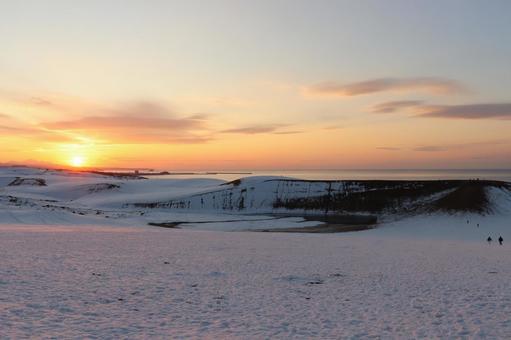 鳥取砂丘の彼方に沈んでいく冬の夕陽 鳥取砂丘,砂丘,雪の写真素材