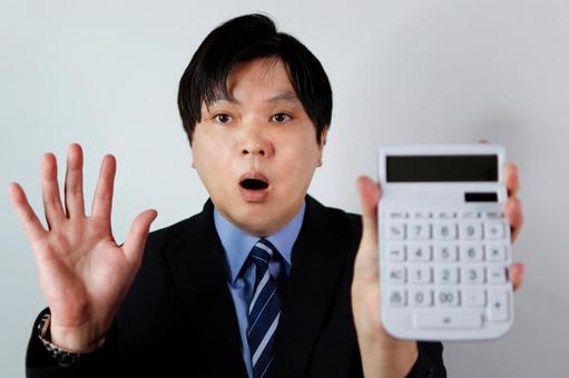 驚くビジネスマンと電卓 驚くビジネスマンと電卓 ビジネスマン,男性,驚きの写真素材