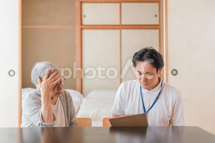 体調不良の高齢者と男性スタッフ 高齢者,訪問医療,在宅医療の写真素材