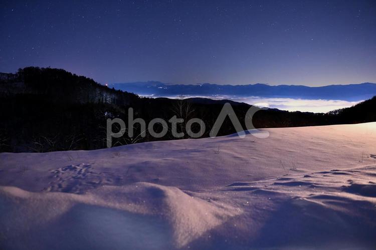 雪の飯綱高原から望む夜の町並みと星空 雪,星空,夜景の写真素材