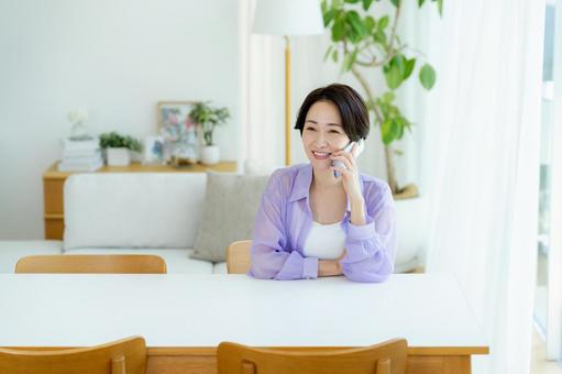 スマホで電話するミドル女性 スマホ,笑顔,女性の写真素材