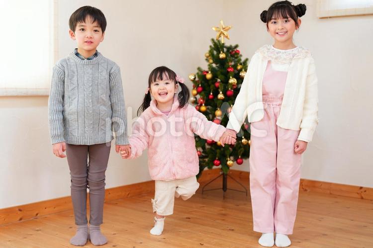 ツインテールの女の子を真ん中にして手を繋ぐ子供たち 男女,手を繋ぐ,仲良しの写真素材