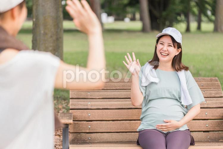 ママ友・友達と待ち合わせをする妊婦 妊婦,手を振る,待ち合わせの写真素材