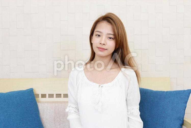 ソファに座り微笑む女性 女性,笑顔,微笑むの写真素材