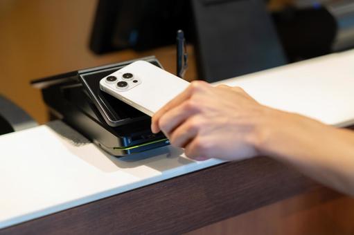 ショッピングをしてモバイル決済をする男性 モバイル決済,ショッピング,買い物の写真素材