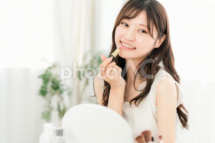 口紅,リップ,グロスを塗る笑顔の女性 口紅,メイク,唇の写真素材