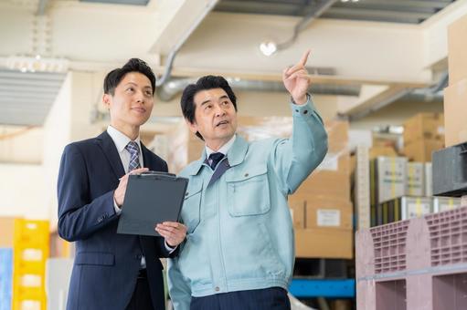 倉庫で商談をする経営者とビジネスマン 倉庫で商談をする経営者とビジネスマン 会議,倉庫,工場の写真素材