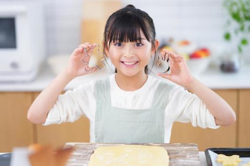 クッキー型を両手に持って笑顔を見せる女の子 女の子,日本人,型抜きの写真素材