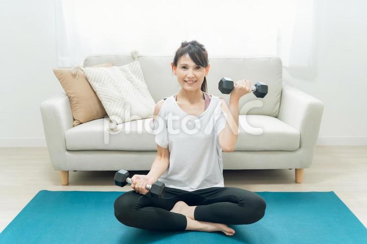 部屋で筋トレをする中高年女性 ダンベル,筋トレ,筋肉の写真素材