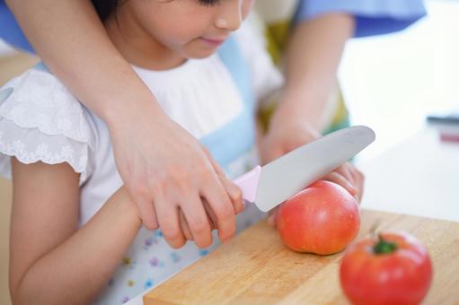 新鮮な野菜を切る親子の料理風景 女の子,トマト,野菜の写真素材
