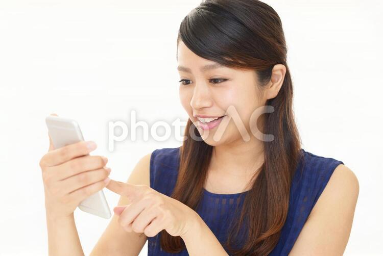 スマートフォンを持つ笑顔の女性 女性,スマートフォン,女の写真素材