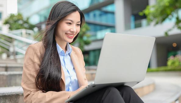 ノートパソコンを持つおしゃれな日本人女性 ノートパソコンを持つおしゃれな日本人女性の写真