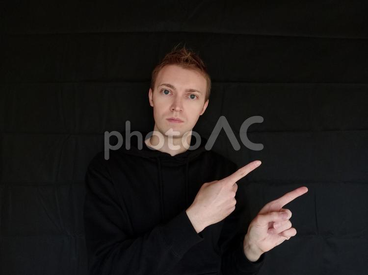 あっち・右　と指さしで方向を教えてる外国人男性　黒バック みぎ,右,あっちの写真素材