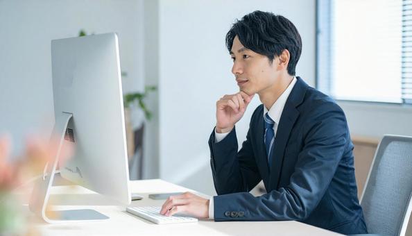 PC作業をするビジネスマン PC作業をするビジネスマンの写真