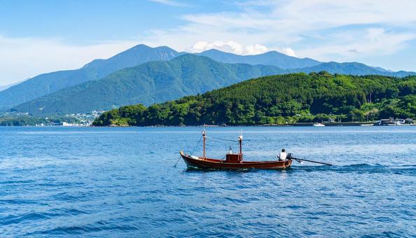 夏の青い海に浮かぶ船と青空 夏の青い海に浮かぶ船と青空の写真