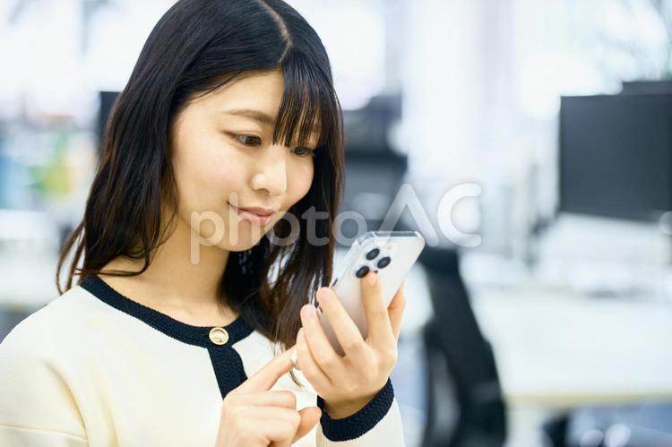 スマホを見る女性　ビジネス　仕事 スマホ,ビジネスウーマン,ビジネスシーンの写真素材