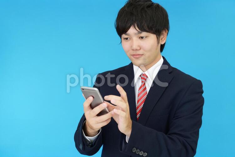 スマートフォンを持つビジネスマン 男性,ビジネスマン,男の写真素材