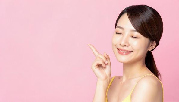 目をつむり目を指差す女性の写真