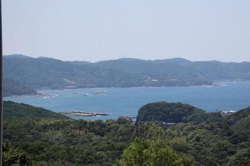 緑の山々と湾になった海と岩礁と空の風景 緑の山々と湾になった海と岩礁と空の風景の写真