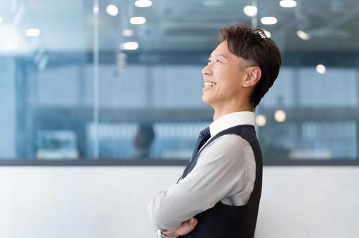 腕組みをする笑顔の男性ビジネスマン 腕組みをする笑顔の男性ビジネスマン 男性,腕組み,笑顔の写真素材