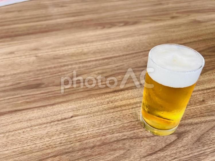 木目テーブルに置かれたビール ビール,グラス,泡の写真素材