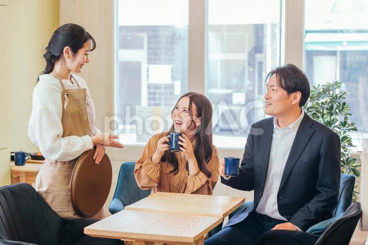 カフェにきた男女とホールスタッフ カフェ,コーヒー,コーヒーショップの写真素材