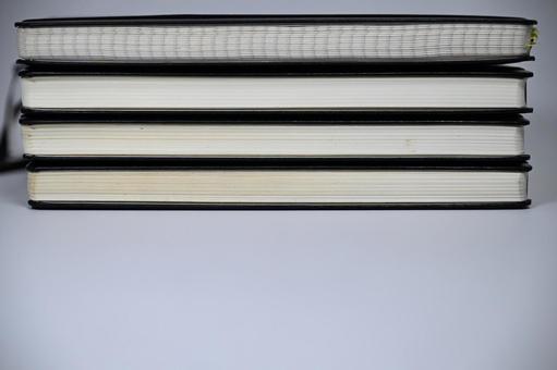 Horizontally stacked black notebooks with blank space at the bottom, JPG