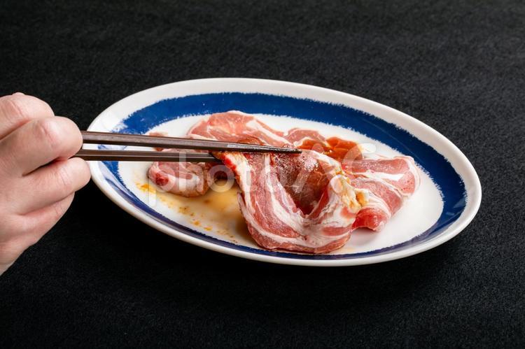 焼肉を箸で持ち上げるシーン 肉,焼肉,豚肉の写真素材