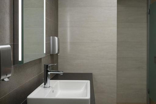 公衆トイレの洗面台と鏡の写真