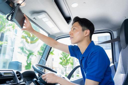 トラックを運転する男性ドライバー トラックを運転する男性ドライバー ドライバー,トラック,運転手の写真素材