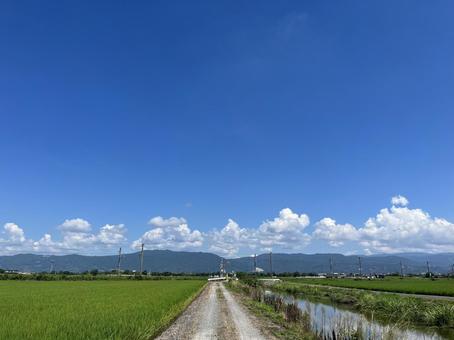砂利道と山と雲と青い空 砂利道と山と雲と青い空の写真