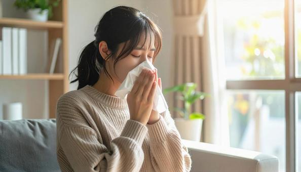 ティッシュで鼻をかむ日本人の若い女性 ティッシュで鼻をかむ日本人の若い女性の写真