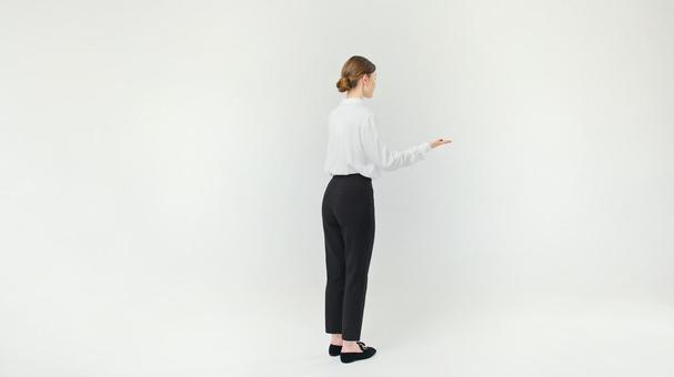 右手を伸ばし説明している横向き女性 右手を伸ばし説明している横向き女性の写真