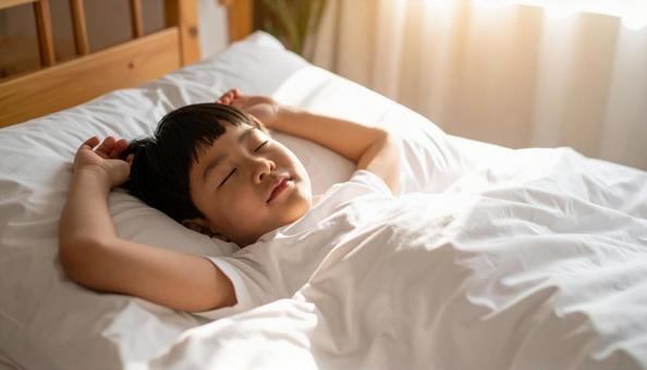 両手をあげて熟睡する男の子 両手をあげて熟睡する男の子の写真