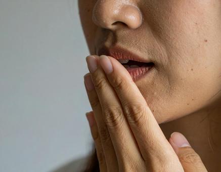口に手を当てる女性 口に手を当てる女性の写真