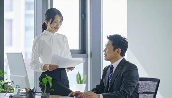 上司に報告する女性社員 上司に報告する女性社員の写真